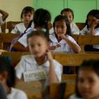 Genesis Tuazon (al fondo a la derecha), de ocho años, está sentada en su clase de la escuela de Panghulo, cerca del Artex Compound en Malabon (Filipinas) el 5 de junio de 2013.