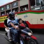 La estudiante Chamaya Pamutito, de 7 años, monta en scooter con su padre y su madre para ir a la escuela en Bangkok (Tailandia), el 6 de junio de 2013.
