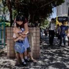 Maia, de 5 años, recibe un abrazo de su niñera en su camino al colegio en Hong Kong, el 18 de junio de 2013.