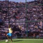 Un joven juega al fútbol en Río de Janeiro (AFP PHOTO / YASUYOSHI CHIBA)