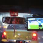 Un taxista observa el Uruguay-Costa Rica en una pequeña televisión mientras conduce (Photo by Joe Raedle/Getty Images)