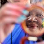 Un mujer se mira al espejo tras ser maquillada con los colores de Brasil (JEWEL SAMAD/AFP/Getty Images)