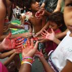 Niños se pintan las manos de rojo antes de una protesta contra el Mundial. (Photo by Mario Tama/Getty Images)