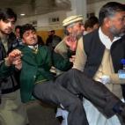 Voluntarios llevan a un estudiante herido a un hospital local de Peshawar, Paquistán. (AP Photo/Mohammad Sajjad)