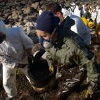 Some of hundreds of volunteers coming from all over of Spain clean the beaches between Oia and Bayona, northwestern Spain, 06 December 2002. Portugal beefed up its anti-pollution measures 05 December as oil slicks from the sunken tanker Prestige...