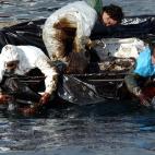 Pescadores de Cangas do Morrazo (Pontevedra) sacando fuel desde su propia embarcaci&oacute;n.