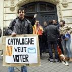 Un joven muestra una pancarta que reza "Cataluña quiere votar" a las afueras de la Delegación del Gobierno catalán en Francia.