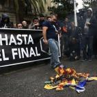 Opositores al 9N queman una Estelada durante una protesta en Barcelona.