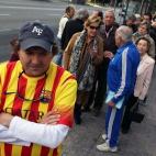 Colas de ciudadanos esperan en la Vía Augusta de Barcelona la apertura de uno de los centros de votación habilitados por el Govern