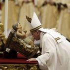 El papa besa una imagen del niño Jesús durante la Misa del Gallo en el Vaticano. (AP Photo/Gregorio Borgia)