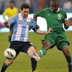 Argentina's Lionel Messi (L) challenges Saudi Arabia's Osama Hawsawi during their friendly football match at King Fahd stadium in the Saudi capital Riyadh on November 14, 2012. The match ended in a goalless draw. AFP PHOTO/FAYEZ NURELDINE ...