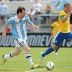Argentine player Lionel Messi (10) kicks past Brazilian player Bruno Uvini to score the first goal during the friendly match Argentina against Brazil at the MetLife Stadium in East Rutherford, New Jersey, on June 9, 2012. AFP PHOTO/Emmanuel Duna...