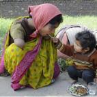 Un niño de dos años da de comer a su madre discapacitada. 