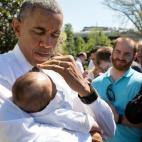 President Barack Obama blocks the sun from a baby's face as he visits with guests following the eighth annual Wounded Warrior Project's Soldier Ride on the South Lawn of the White House, April 16, 2015. (Official White House Photo by Pete Souza)