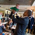 President Barack Obama lifts a baby while greeting patrons prior to lunch at The Coupe restaurant in Washington, D.C., Jan. 10, 2014. (Official White House Photo by Pete Souza)