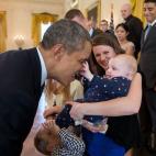 President Barack Obama plays with 5 month-old Vann Carroll during a visit with wounded warriors and their families who were touring the White House, in the East Room, March 31, 2014. Vann was visiting with mom Ryan Carroll and dad, Major Ben Car...