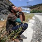 Un afgano bebe agua, tras cruzar la frontera de Turqu&iacute;a con Ir&aacute;n.