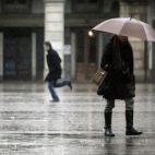 Varias personas caminan bajo la lluvia por la plaza de María Pita, en A Coruña.