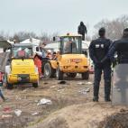 Policemen stand as agents and bulldozers dismantle shacks on March 1, 2016 in the 'Jungle' migrant camp in the French northern port city of Calais. Workers were due to start a second day of destruction in the southern half of the camp, where tho...