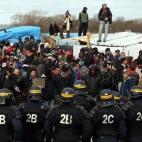 CALAIS, FRANCE - FEBRUARY 29: Police officers face activists and migrants as part of the 'jungle' migrant camp is cleared on February 29, 2016 in Calais, France The French authorities have begun dismantling part of the migrant encampment in th...