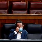 El vicepresidente del gobierno Pablo Iglesias escucha la intervenci&oacute;n del l&iacute;der de Vox, Santiago Abascal.