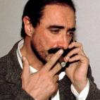 Leading Spanish Radio journalist Carlos Herrera smokes a cigar as he speaks on the phone from his home in Seville March 27 after receiving a letter bomb with 150 grammes of dynamite in a cigar package. The journalist was suspicious the packet wa...