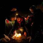 Leona Wieland, de 65 años, al centro, enciende velas y veladoras con la hermana Janice Klein, a la izquierda, afuera de una penitenciaria en Sioux Falls, Dakota del Sur, en protesta por la ejecución en el lugar de Donald Moeller, acusado de la...