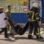 EDITORS NOTE: Graphic content / People clear out bodies after a rocket attack killed at least 35 people on April 8, 2022 at a train station in Kramatorsk, eastern Ukraine, that was being used for civilian evacuations. (Photo by FADEL SENNA / AFP...