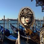Una participante en el carnaval de Venecia posa mirándose al espejo en el muelle de la ciudad.