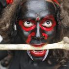 Un hombre vestido de demonio actúa en una procesión religiosa del festival Mahashivratri, en la ciudad de Allahabad (norte de India).