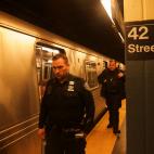 Agentes patrullan el interior del metro en Manhattan tras el tiroteo en Brooklyn