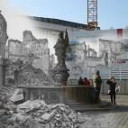 Edificios en ruinas alrededor de la plaza Neumarkt, presidida por una fuente con estatua. En 2015, unos turistas se sacan una foto.