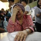 Una mujer, que cree que su hermana iba en el avión siniestrado, a la espera de noticias en el aeropuerto internacional de Sepang