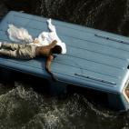 Un hombre intenta salvar su vida encima de una furgoneta tras los daños del huracán Katrina en Nueva Orleans en 2005.