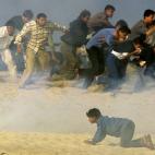 Palestinos huyen de soldados israelíes al sur de Gaza en el año 2000.