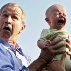 George W. Bush sostiene a un bebé llorando en una visita a Alemania en 2006.