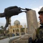 Un soldado de EE.UU. contempla la caída de la estatua de Saddam Hussein en Irak el 9 de abril de 2003.