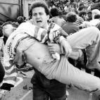 Un aficionado intenta ayudar a uno de los heridos de la tragedia de Haysel (Bruselas) en 1985. Aquel 29 de mayo se jugaba la final de la Copa de Europa entre Liverpool y Juventus. Murieron 39 personas.