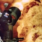 Bomberos tratan de apagar un incendio en los pozos de petróleo de Al-Ahmadi provocado por las fuerzas de Saddam Hussein el 30 de marzo 1991.