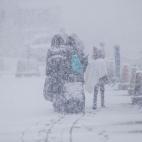 Refugiados ucranianos caminan bajo una intensa nevada, en la localidad rumana de Siret.