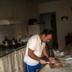 Antonio García, de 50 años, corta un pedazo de carne tras la jornada de trabajo