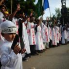 Activistas de la rama estudiantil del partido islámico pakistaní Jamaat-e-Islami visten sudarios con lemas a favor de los Hermanos Musulmanes y los partidarios de Morsi fallecidos durante las protestas.