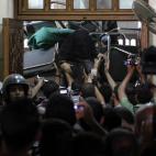 Una mujer atraviesa una barricada levantada por simpatizantes de Morsi dentro de la mezquita al-Fath, en El Cairo.