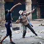 Simpatizantes de Morsi y los Hermanos Musulmanes lanzan piedras a las fuerzas de seguridad en la plaza de Ramsés durante los enfrentamientos del viernes de la ira.