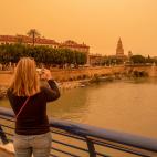 Una mujer hace una fotografía con su móvil del aspecto que presentaba la ciudad de Murcia este lunes.