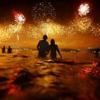 Un grupo de personas observan los fuegos artificiales en Río de Janeiro durante la celebración del Año Nuevo.