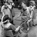 Niños juegan con sus máscaras antigás puestas en 1940.