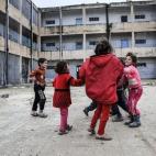 Niños juegan en el patio de un edificio destruido en el centro de la ciudad siria de Kobani el 18 de febrero de 2015.