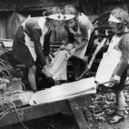Niñas de Londres practican primeros auxilios a sus muñecas el 6 de octubre de 1940.