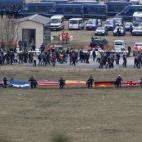 Banderas de los países que han sufrido pérdidas humanas en el accidente de Germanwings ondean juntas en una ceremonia frente a los familiares y seres queridos de las víctimas en el lugar del accidente.